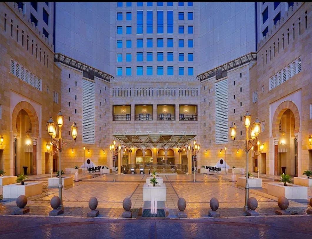 Illuminated hotel courtyard and entrance at dusk