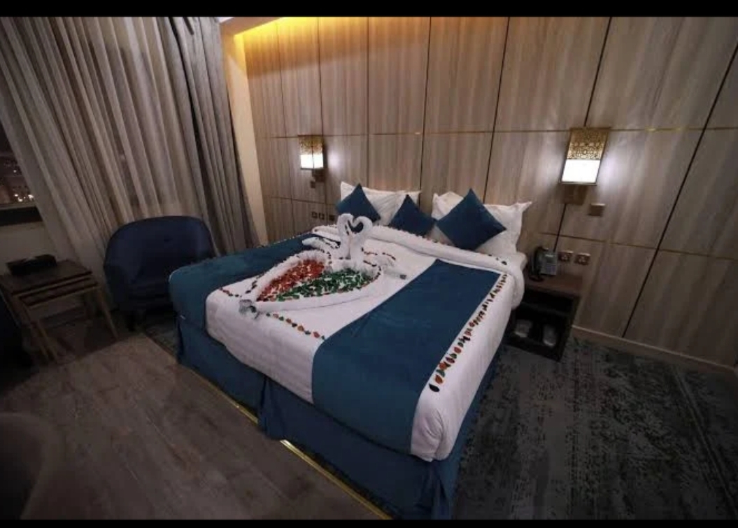 Bedroom in a 3 star Makkah hotel with a double bed and armchair