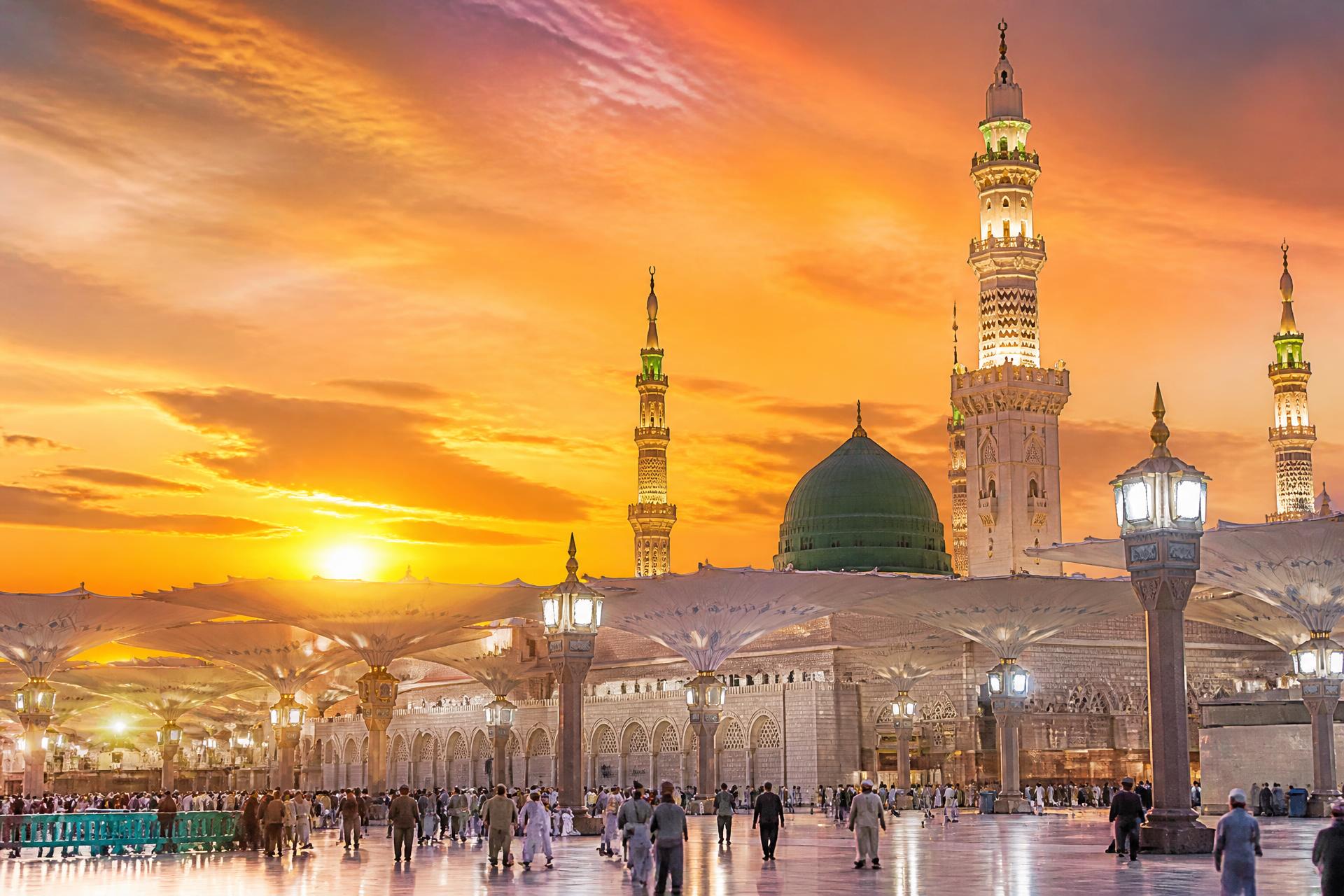 Masjid an-Nabawi in Madinah glowing under a golden sunset sky