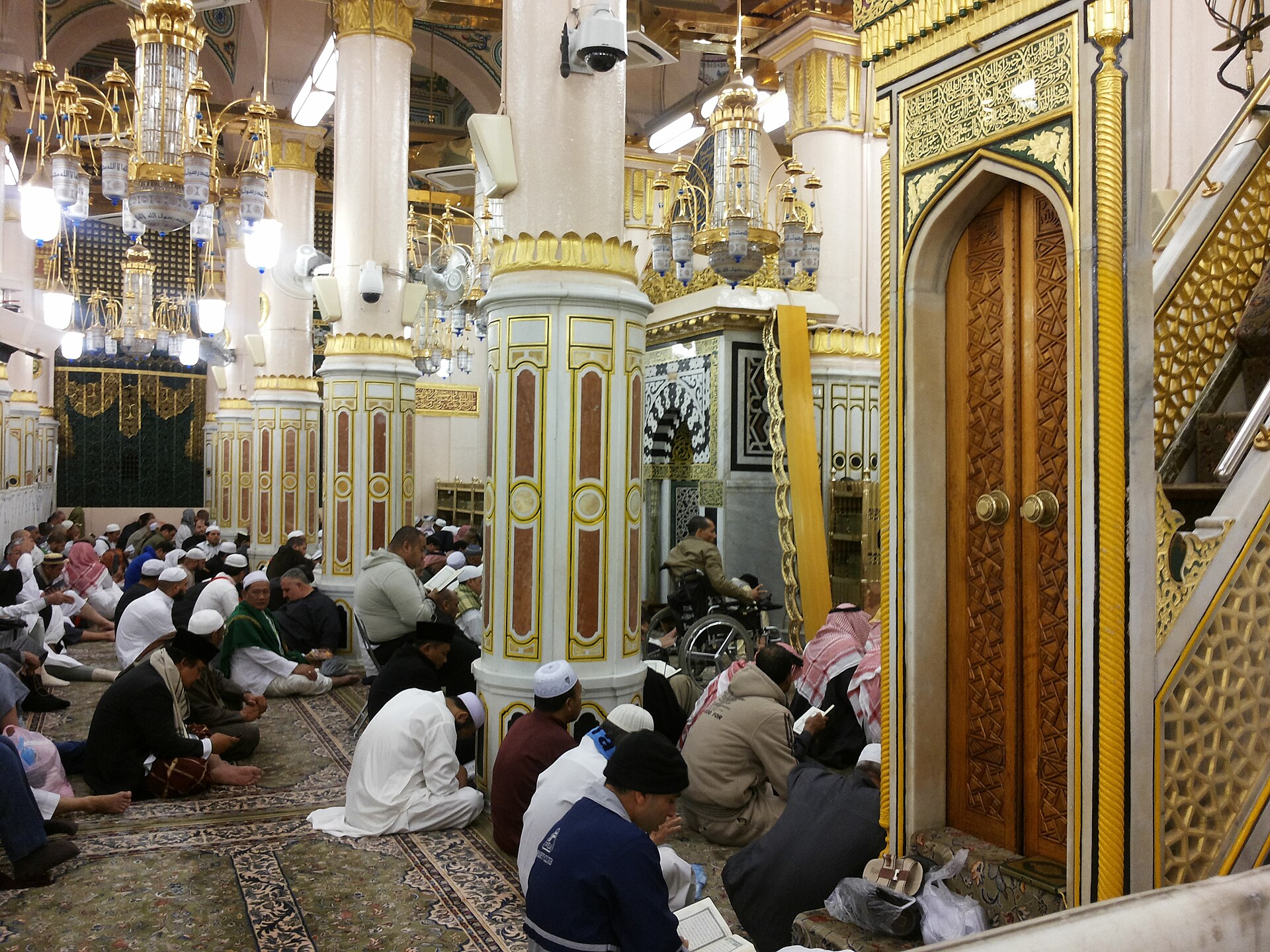 Pilgrims praying and reading Qur'an inside Al-Masjid an-Nabawi near the Rawdah and the Prophet's ﷺ pulpit